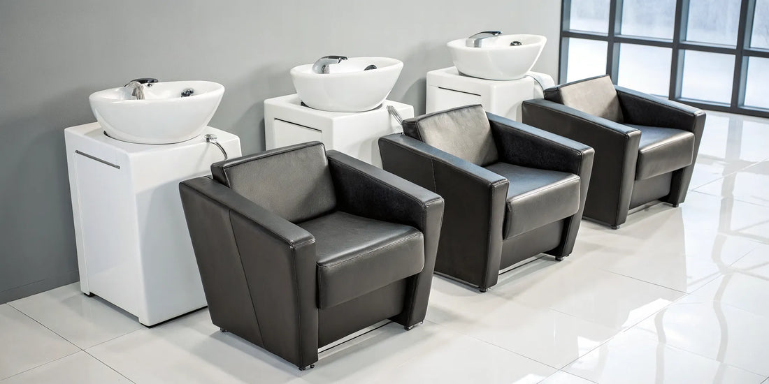 Row of affordable backwash shampoo units with comfortable black chairs and white basins.