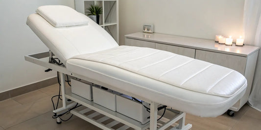 An adjustable esthetician bed for sale with comfortable padding shown in a modern spa treatment room.