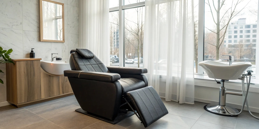 A modern hydraulic reclining shampoo chair with an attached basin for a professional salon.