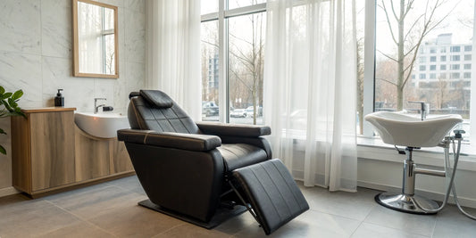 A modern hydraulic reclining shampoo chair with an attached basin for a professional salon.